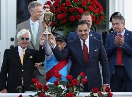 Medina Spirit trainer Bob Baffert (left) and owner Amr Zedan flank jockey John Velazquez as they hoist the Kentucky Derby trophy. Baffert and Zedan filed suit Tuesday to protect Medina Spirit's Derby victory. (Image: AP Photo)