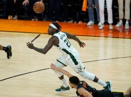 Jrue Holiday from the Milwaukee Bucks eyes a loose ball after forcing Devin Booker of the Phoenix Suns to commit a turnover in the closing seconds of Game 5 of the NBA Playoffs at Phoenix Suns Arena. (Image: Ross D. Franklin/AP)