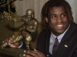 Ricky Williams poses with his 1998 Heisman Trophy. In 2019, Williams sold the trophy for $504,000 in auction (Image: Suzanne Plunket/AP).