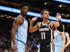 Jimmy Butler of the Miami Heat and Trae Young from the Atlanta Hawks await a call from an official. (Image: Todd Kirkland/Getty)