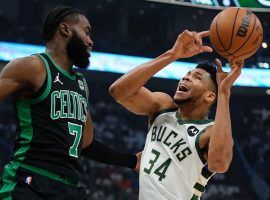 Giannis â€˜Greek Freakâ€™ Antetokoumpo tries to get a grip on a loose ball, while Jaylen Brown from the Boston Celtics looks on. (Image: Getty)