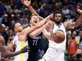 Luka Doncic from the Dallas Mavs dribbles into traffic and gets swarmed by Steph Curry and Draymond Green from the Golden State Warriors. (Image: Porter Lambert/Getty)