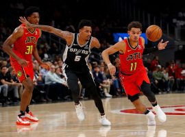 Dejounte Murray from the San Antonio Spurs tips the ball away from Trae Young of the Atlanta Hawks, but now the two adversaries will become teammates after a huge trade. (Image: USA Today Sports)