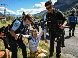 French police remove climate change protestors from the middle of the road in Magland during Stage 10 of the 2022 Tour de France. (Image: Reuters)